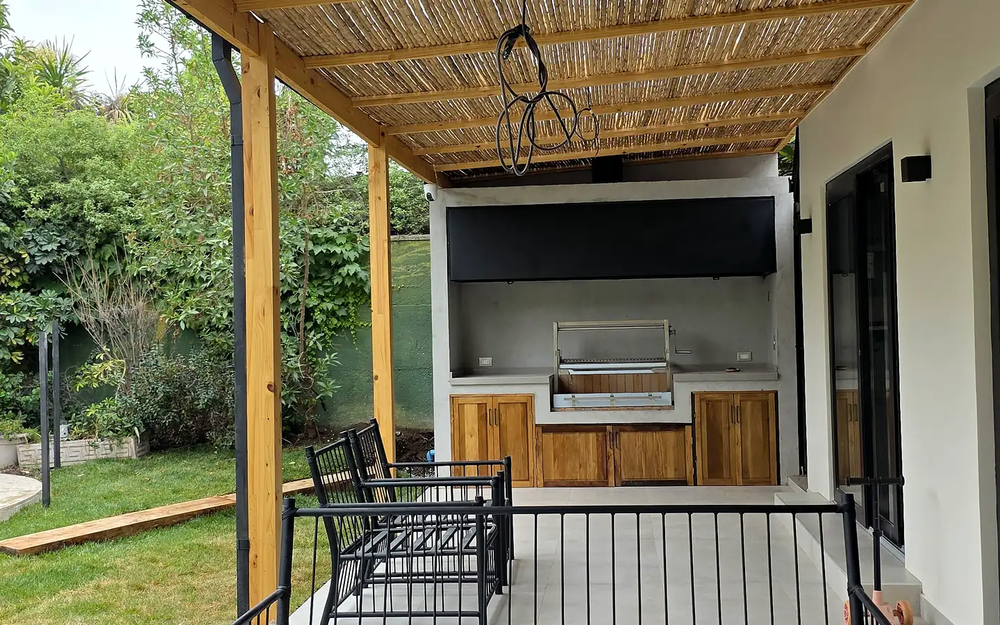 Casa Ossa: terraza cubierta con cielo de coligüe frente al jardín y la piscina