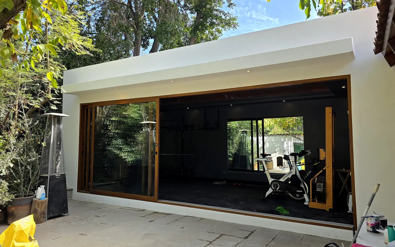 Gimnasio Casa Cortés: pabellón vidriado con cielo de madera abierto al jardín